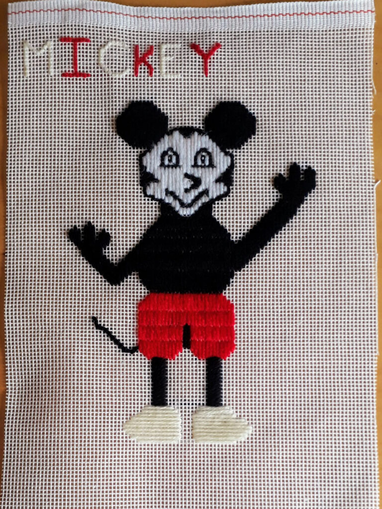 Simplified Mickey Mouse stitched with wool on canvas.