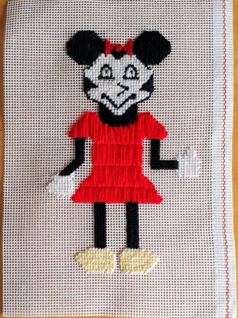 Simplified Minnie Mouse stitched with wool on canvas.