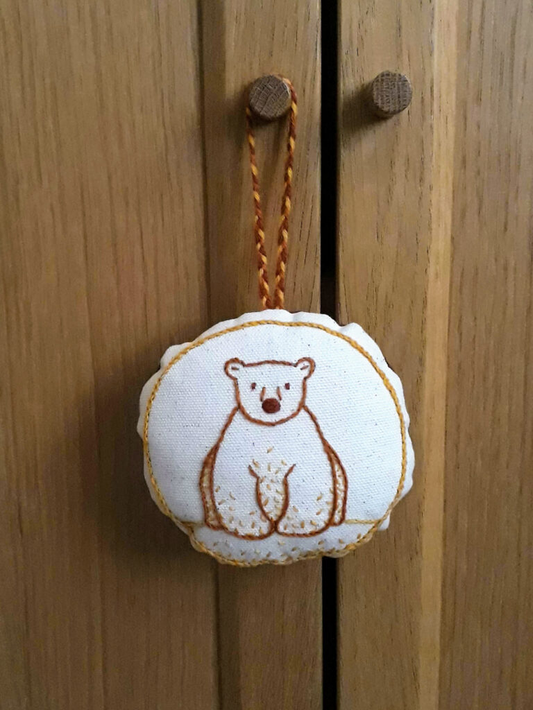 Circular hanging ornament featuring a cute bear design.