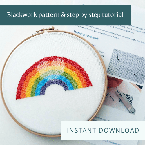 Embroidery of a rainbow with a shaded heart inside it framed in a hoop with a page of instructions behind. Text overlay says "Blackwork pattern & step by step tutorial" and "Instant download".