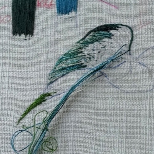 Embroidery sampling of the side of a leaf, stitched with different shades of green-greys.